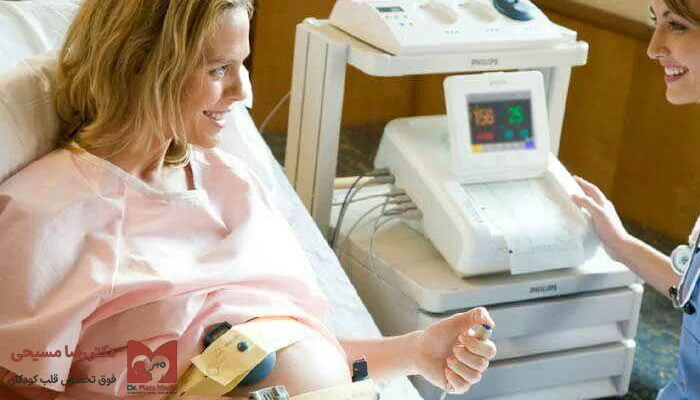 خانم باردار در حال انجام تست مانیتورینگ قلب جنین در کنار پرستار یا پزشک